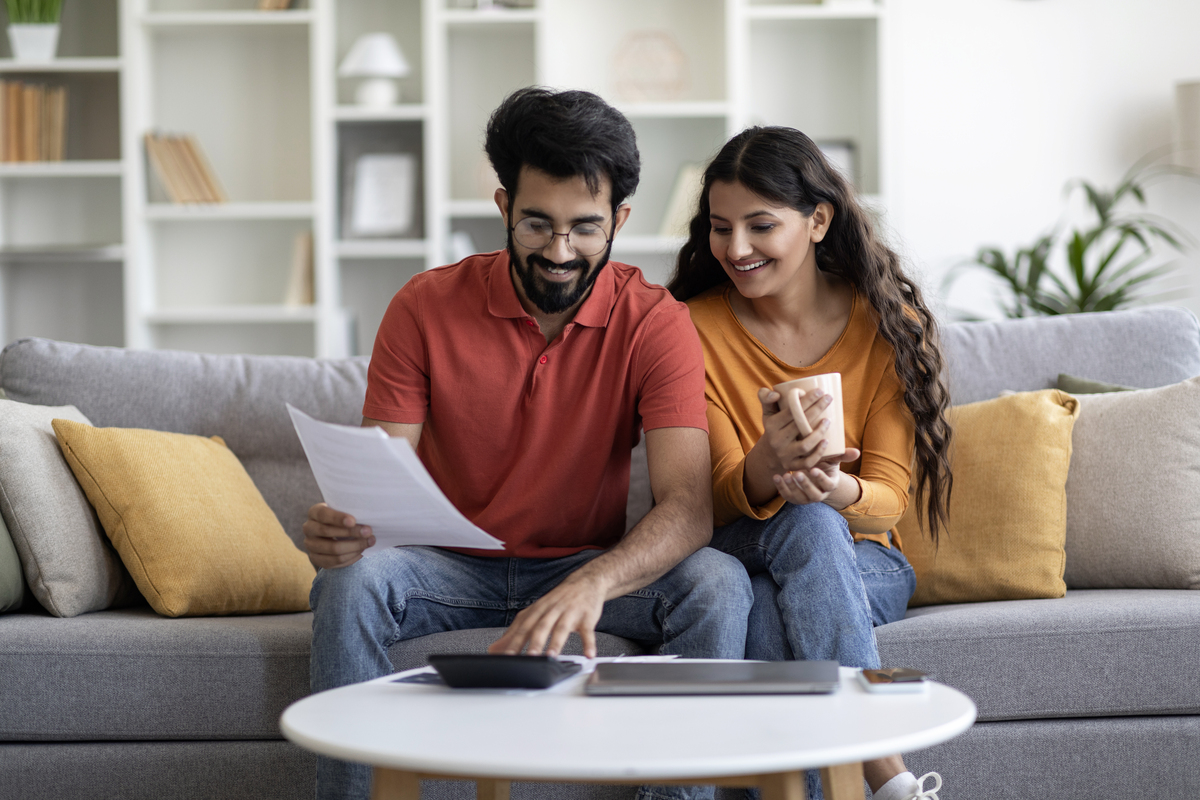 professional Indian financial advisor consulting with clients, modern office setting, warm lighting, professional atmosphere